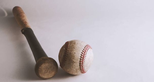 Baseball bat ja pallo valkoisella pohjalla
 - Valokuva, kuva