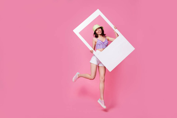 Πλήρης φωτογραφία μεγέθους του ενεργού χαρούμενο κορίτσι άλμα χέρια κατέχουν χαρτί κάρτα άλμπουμ απομονώνονται σε ροζ φόντο χρώμα. - Φωτογραφία, εικόνα