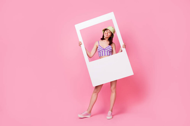 Full length photo of funky dreamy girl dressed violet top rising white photo frame isolated pink color background. - Photo, Image