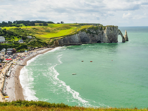 Famous view of Etretat coastline, green fields and vertical chalk cliffs with characteristic arch and pinnacle, Normandy, France - Фото, зображення