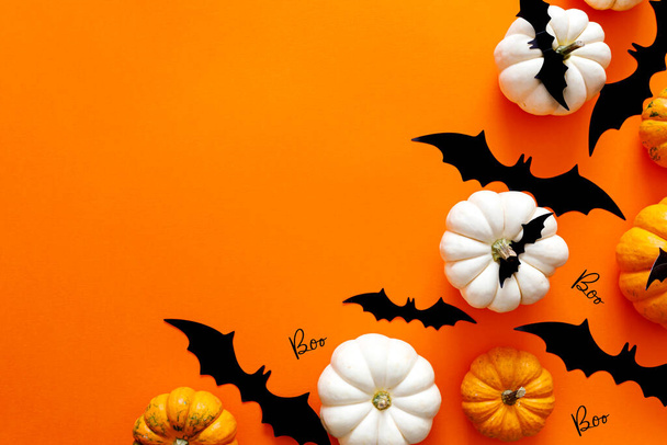 Composición plana de Halloween de murciélagos de papel negro y calabazas sobre fondo naranja. Concepto Halloween. - Foto, imagen
