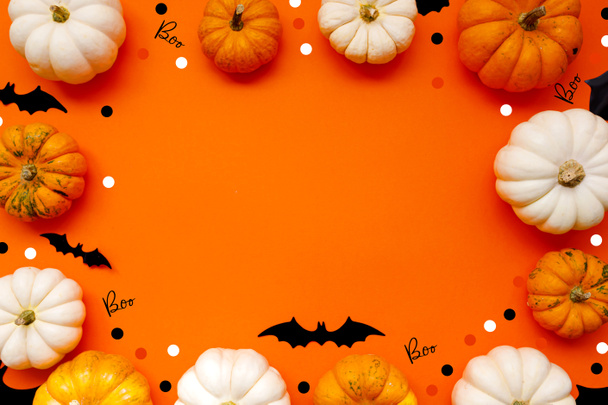 Halloween plochý ležel složení černých papírových netopýrů a dýně na oranžovém pozadí. Halloween koncept. - Fotografie, Obrázek