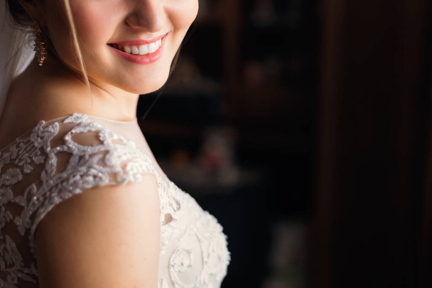detailní záběr na spodní polovinu tváře nevěsty s úsměvem. rozmazané pozadí. - Fotografie, Obrázek