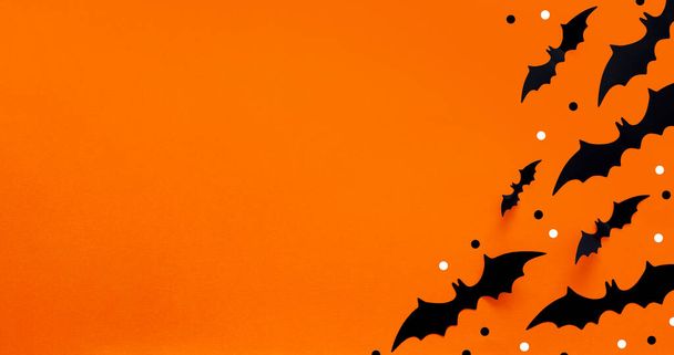 Halloween flache Komposition aus schwarzen Papierfledermäusen und Kürbissen auf orangefarbenem Hintergrund. Halloween-Konzept. - Foto, Bild
