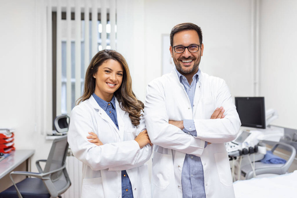 Portret uśmiechniętych młodych lekarzy stojących razem. Portret personelu medycznego w nowoczesnym szpitalu uśmiechnięty do kamery - Zdjęcie, obraz