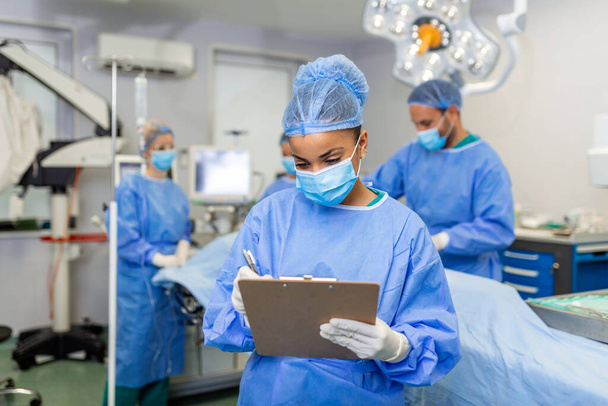 Chirurg schrijven op Klembord in operatiekwartier - Foto, afbeelding