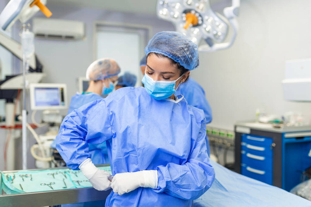 Νεαρή γυναίκα χειρουργός ετοιμάζεται να χειρουργήσει - Φωτογραφία, εικόνα
