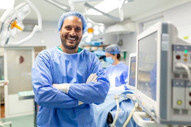 Ameliyathanede çalışan anestezi uzmanı koruyucu giysi giyerek hastaya hastanede ameliyat öncesi sakinleştirici verirken monitörleri kontrol ediyor. - Fotoğraf, Görsel