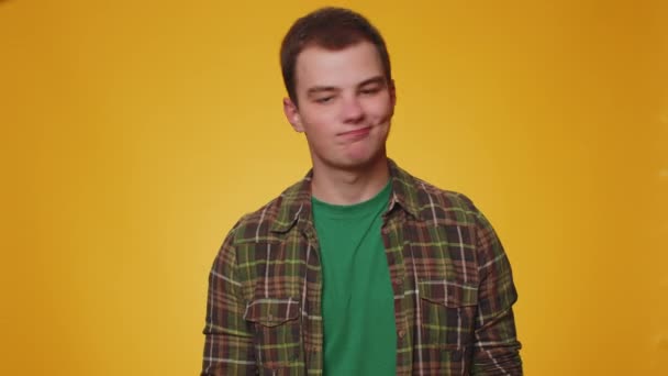 Displeased upset man reacting to unpleasant awful idea, dissatisfied with bad quality, wave hand, shake head No, dismiss idea, dont like proposal. Young teen boy alone on yellow studio wall background - Footage, Video