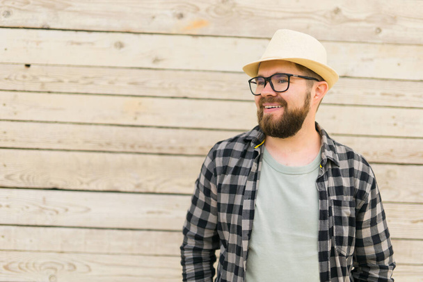 Laughing attractive man wearing hat over wooden background - emotion and vacation travel holidays - 写真・画像