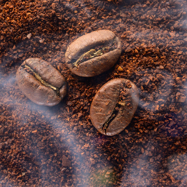 コーヒー豆と挽いたコーヒーの上からの眺め熱で蒸す焙煎コーヒースモーキーなコーヒーの食感. - 写真・画像