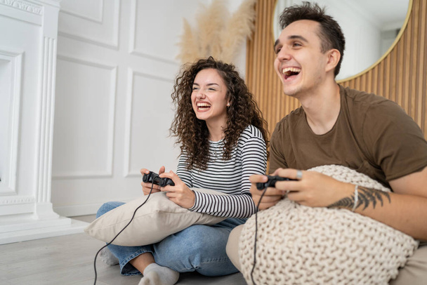Два человека пара мужчина и женщина бойфренд и девушка муж и жена или друзья играют в консольные видеоигры держать джойстик контроллер счастливая улыбка эмоциональный жест реакции семейный досуг копировать пространство - Фото, изображение