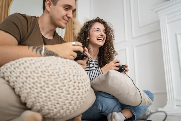 Twee mensen paar man en vrouw vriend en vriendin man en vrouw of vrienden spelen console video games houden joystick controller gelukkig glimlach emotioneel gebaar reactie familie vrije tijd kopiëren ruimte - Foto, afbeelding