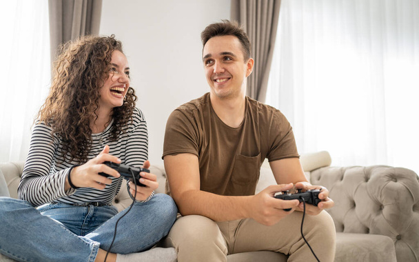 Two people couple man and woman boyfriend and girlfriend husband and wife or friends play console video games hold joystick controller happy smile emotional gesture reaction family leisure copy space - 写真・画像