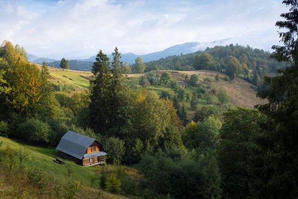 casa tradicional de madera sobre el telón de fondo de un paisaje de montaña. Cárpatos ucranianos - Foto, imagen