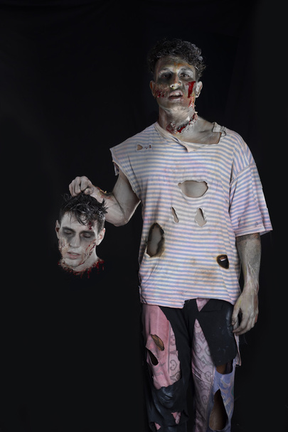 Scary male zombie holding another mans head - Photo, image