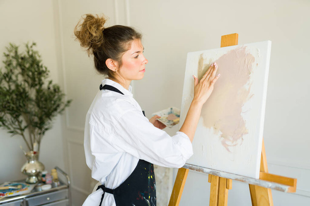 Pittore donna di talento utilizzando le dita per creare un nuovo dipinto e sentirsi ispirato con il suo hobby artistico - Foto, immagini