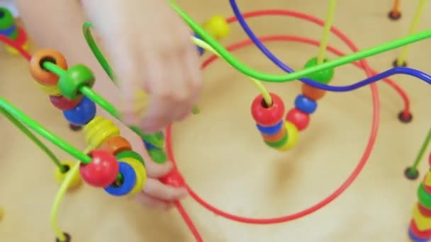Kids Hands Playing Wooden Wire Maze Educational Game Toy toddler blocks. A game for the development of logic and fine motor skills of hands. Close-up. Selective focus - Footage, Video