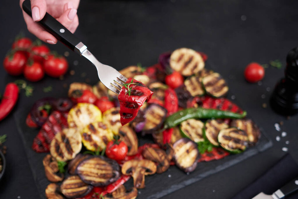 Grilled vegetables mix on a stone serving board - zucchini eggplant onions corn mushroom tomato. - Фото, изображение