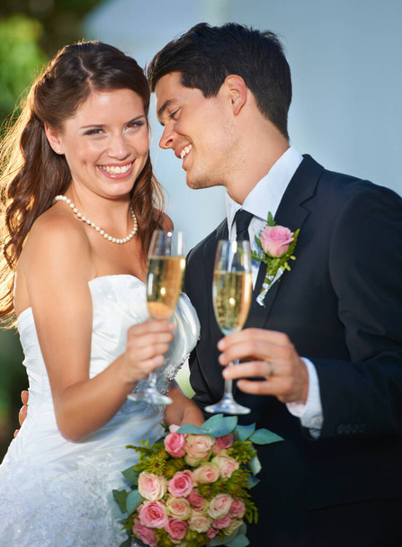 Brindo por la feliz pareja. un joven novio brindando a su novia con champán y sonriendo - Foto, Imagen