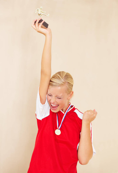 Liga-MVP. eine junge Frau in Fußballuniform feiert und hält eine Trophäe in die Höhe - Foto, Bild