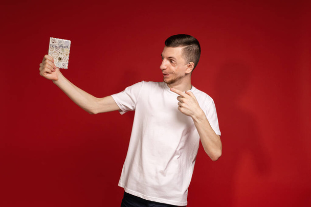 Mladý muž v bílém tričku se syndromem zrady má pas. - Fotografie, Obrázek