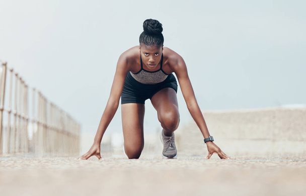 Fitness, runner and woman start running workout along beach, cardio and speed training. Sports, exercise and portrait of black woman prepare for marathon with morning run, serious, focus and intense. - Photo, Image