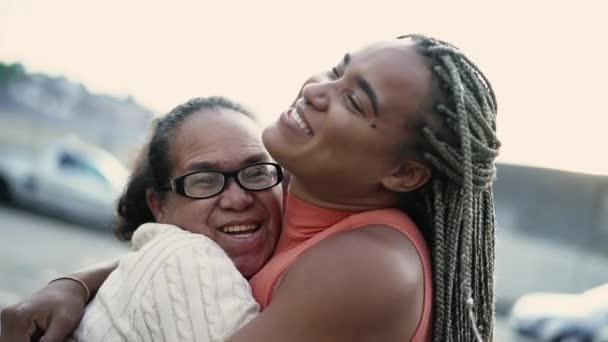 Vreugdevolle oudere oma en volwassen dochter knuffelen buiten. Zuid-Amerikaans Braziliaans volk familie liefde en genegenheid - Video