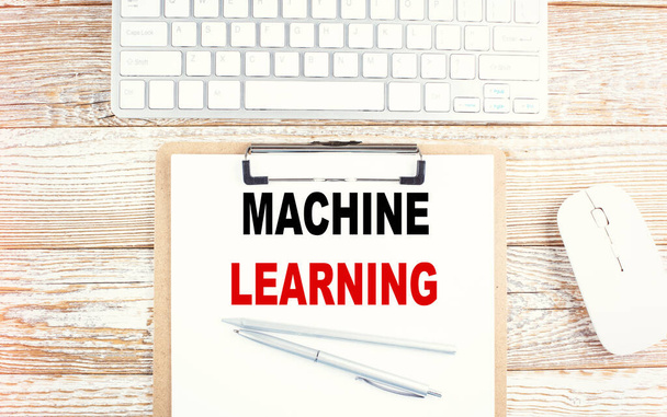 MACHINE LEARNING tekst op klembord met toetsenbord op houten achtergrond - Foto, afbeelding