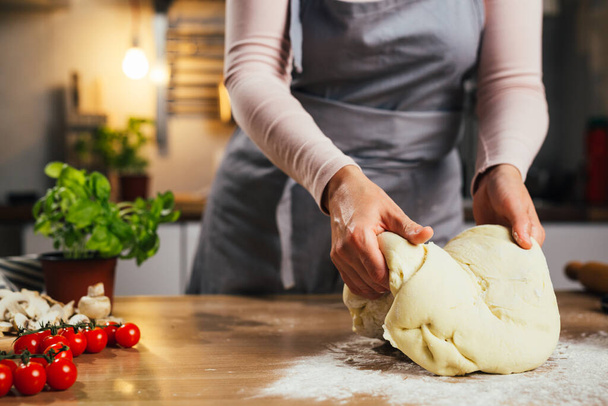 close up of woman preparing dough in home kitchen - Foto, afbeelding