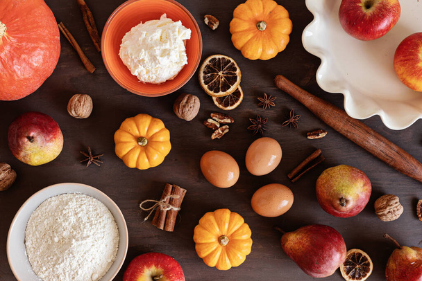 Fall pie baking ingredients with pumpkins, apples, pears, nuts, seasonal spices and tools. Cooking pumpkin or apple pie. Thanksgiving and autumn holidays celebration concept - Zdjęcie, obraz