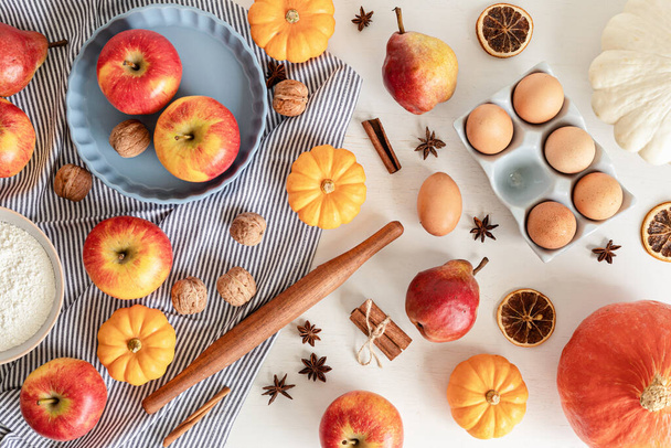 Fall pie baking ingredients with pumpkins, apples, pears, nuts, seasonal spices and tools. Cooking pumpkin or apple pie. Thanksgiving and autumn holidays celebration concept - Foto, afbeelding