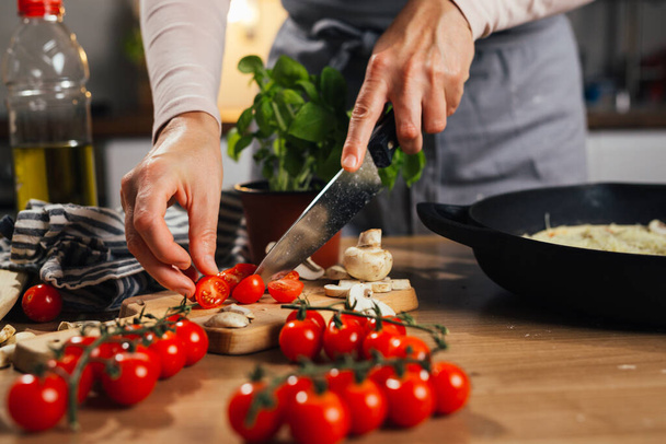 woman chopping with knife cherry tomatoes - Zdjęcie, obraz