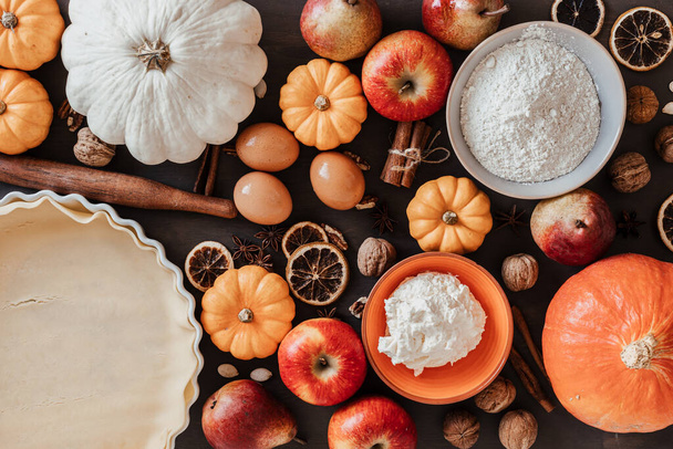 Herbstkuchenbackzutaten mit Kürbissen, Äpfeln, Birnen, Nüssen, saisonalen Gewürzen und Werkzeugen. Kürbis- oder Apfelkuchen kochen. Konzept für Erntedank- und Herbstferienfeier - Foto, Bild