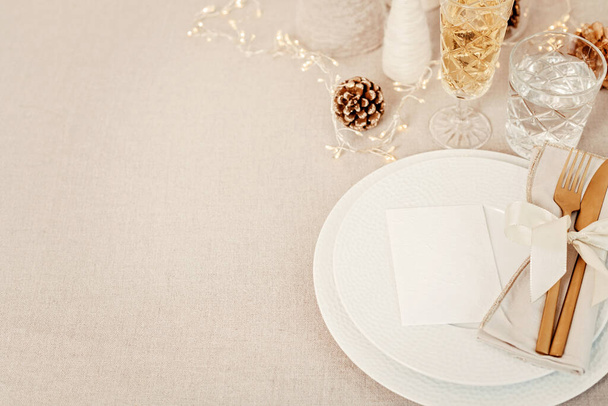 Mesa de Navidad festiva con cubiertos dorados y placa de porcelana y decoración de Navidad. Mockup para tarjeta de lugar, invitación a cenar, plantilla de menú de restaurante. Copiar espacio - Foto, Imagen