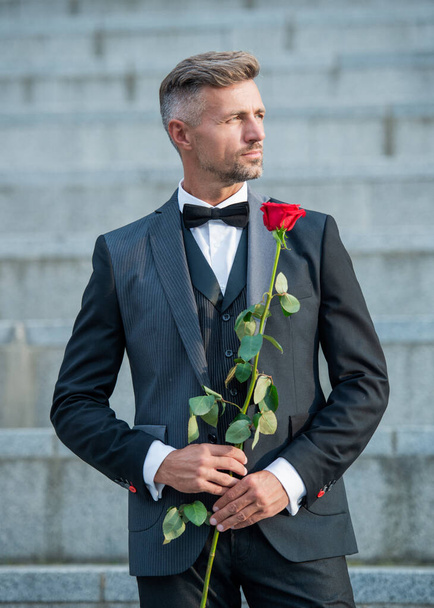 special occasion concept. hoary man with rose for special occasion. tuxedo man outdoor at special occasion. - Foto, Imagem