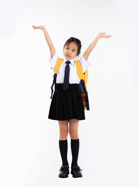 Back to school. Asian junior school student in uniform posing on white background. - Foto, afbeelding