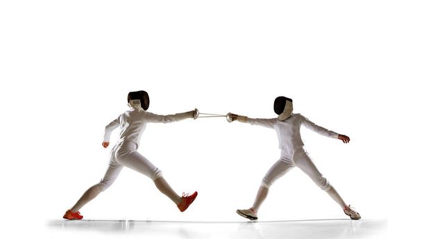 Дві жіночі огорожі спортсмени борються ізольовані на білому
 - Фото, зображення