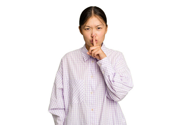 Fiatal ázsiai nő elszigetelt zöld króm háttér tartja a titkot, vagy kéri a csendet. - Fotó, kép
