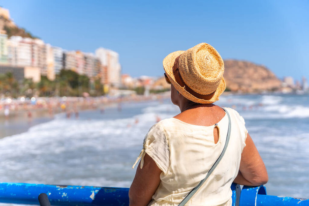 Alicante 'deki Postiguet plajında yaşlı bir kadın, geziler, yaşlılar için tatiller... - Fotoğraf, Görsel