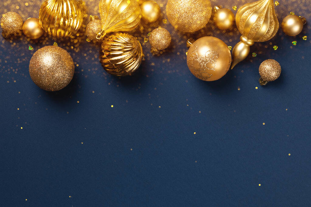 Altın parıltılı toplarla Noel afişi ve mavi arka planda fotokopi alanı olan oyuncaklar - Fotoğraf, Görsel