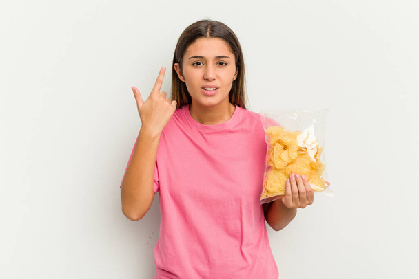 Young Indian woman holding crips isolated on white background showing a disappointment gesture with forefinger. - Fotografie, Obrázek