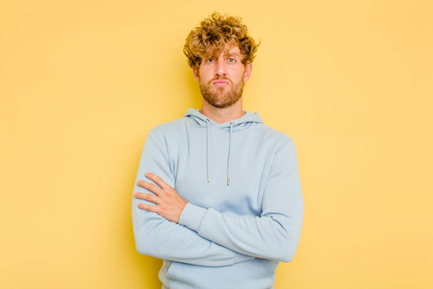 Young caucasian man isolated on yellow background unhappy looking in camera with sarcastic expression. - Photo, Image