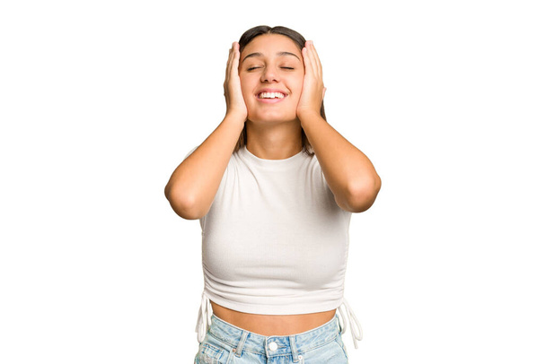 Joven mujer india aislado recorte retiro fondo risas alegremente mantener las manos en la cabeza. Concepto de felicidad. - Foto, Imagen