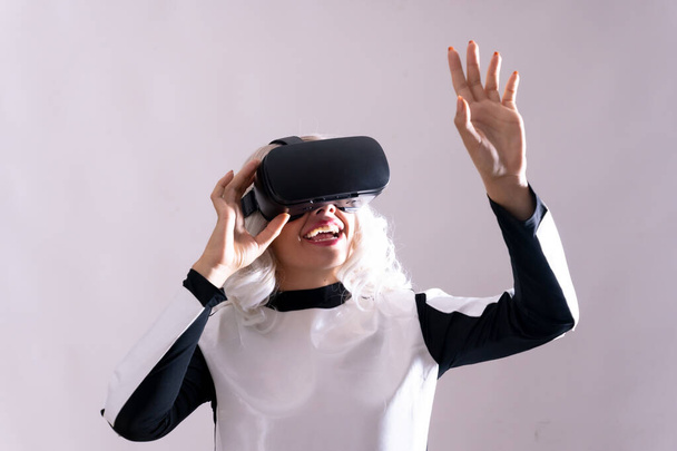 Close-up of adult woman gesturing with virtual reality goggles, metaverse - Fotografie, Obrázek