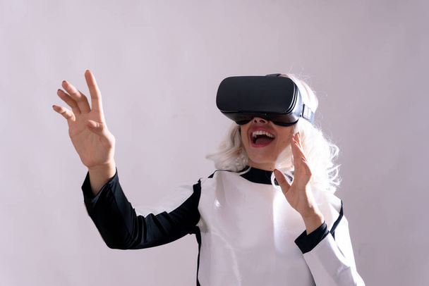 Woman wearing virtual reality glasses, futuristic concept, metaverse surprised with virtual world - Foto, imagen