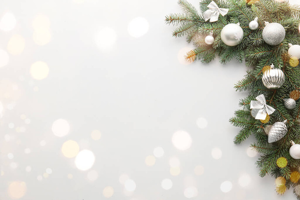 Mooie kerstboom takken met decor op lichte achtergrond met ruimte voor tekst - Foto, afbeelding