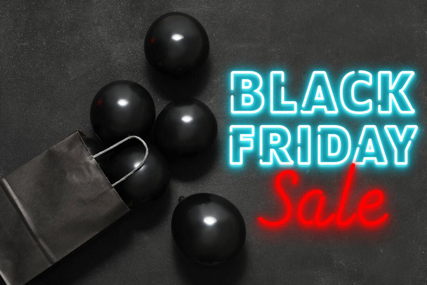 Luftballons und Einkaufstasche auf dunklem Hintergrund. Black-Friday-Verkauf - Foto, Bild