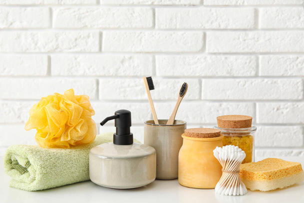 Set of bath supplies on table against light brick wall - Photo, Image