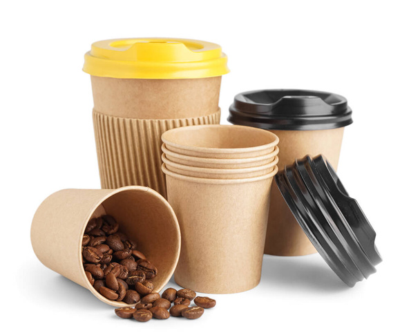 Tazas de papel para llevar y granos de café sobre fondo blanco - Foto, imagen